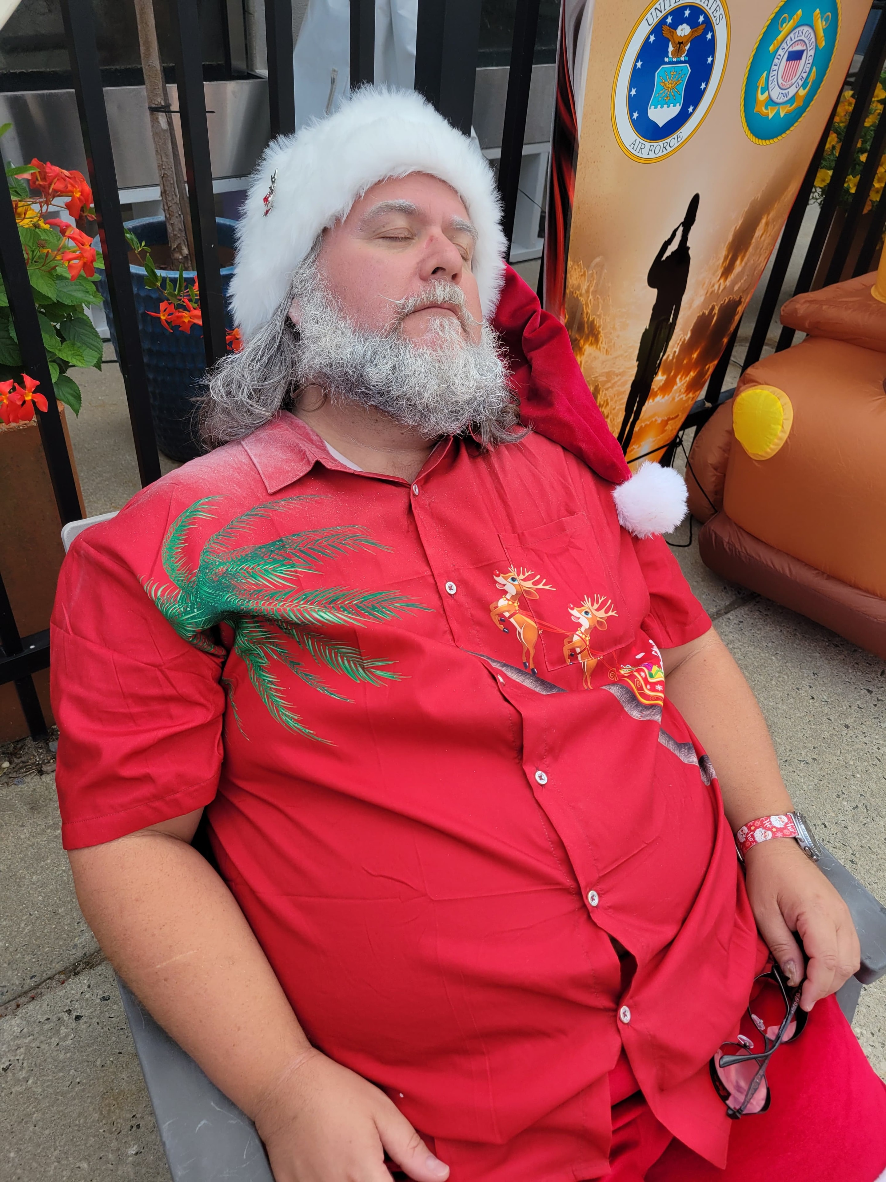 Cape May County Santa napping in a chair at an outdoor military appreciation event