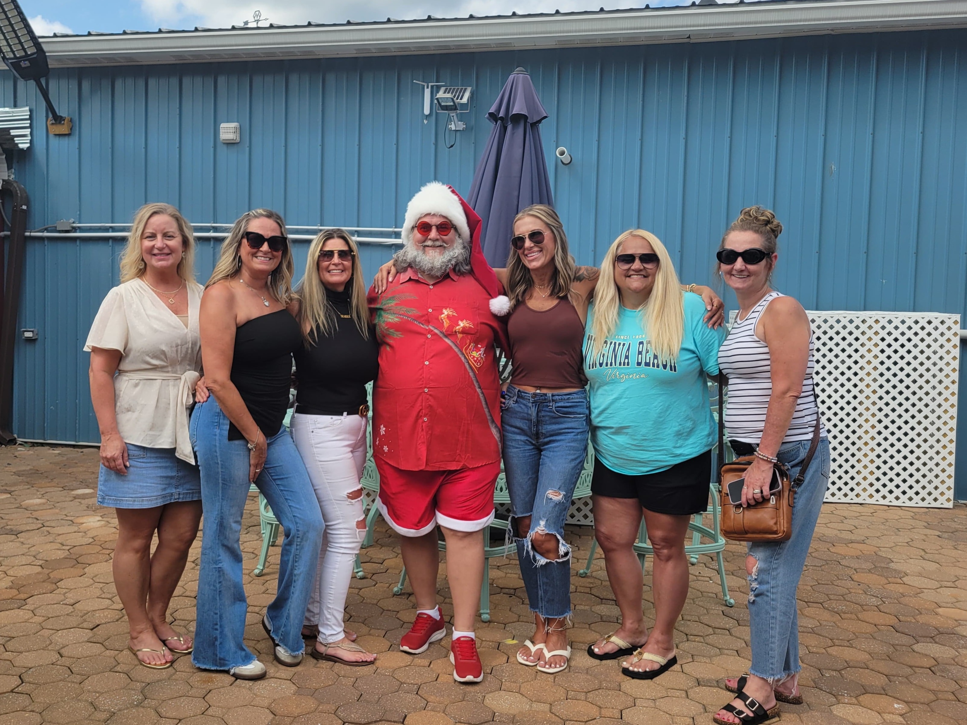 Cape May County Santa posing with a group of six women at an outdoor patio event