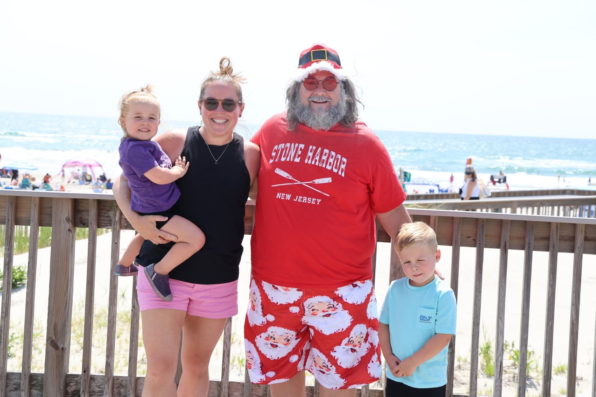 Cape May County Santa with a mom and two kids on the Stone Harbor boardwalk