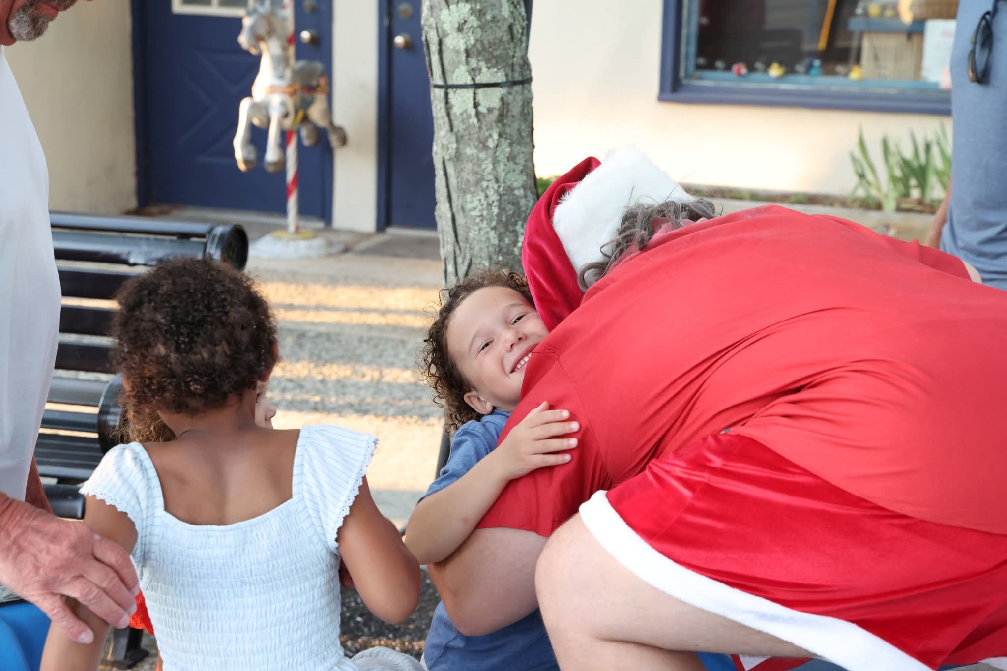 Cape May County Santa hugging a toddler boy who is beaming with joy