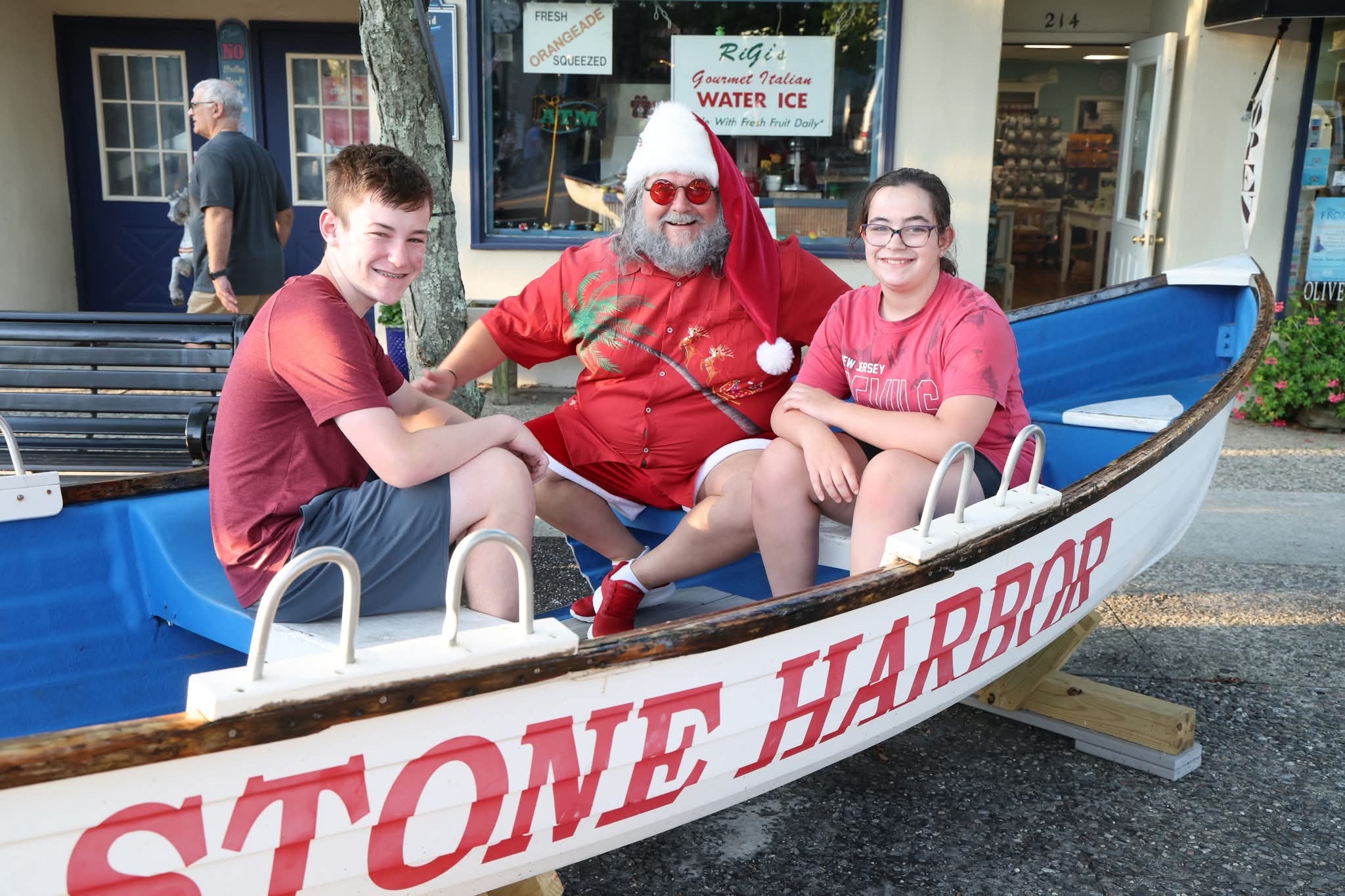 Cape May County Santa with a teenage boy in a NJ Devils shirt and a teenage girl in the Stone Harbor boat