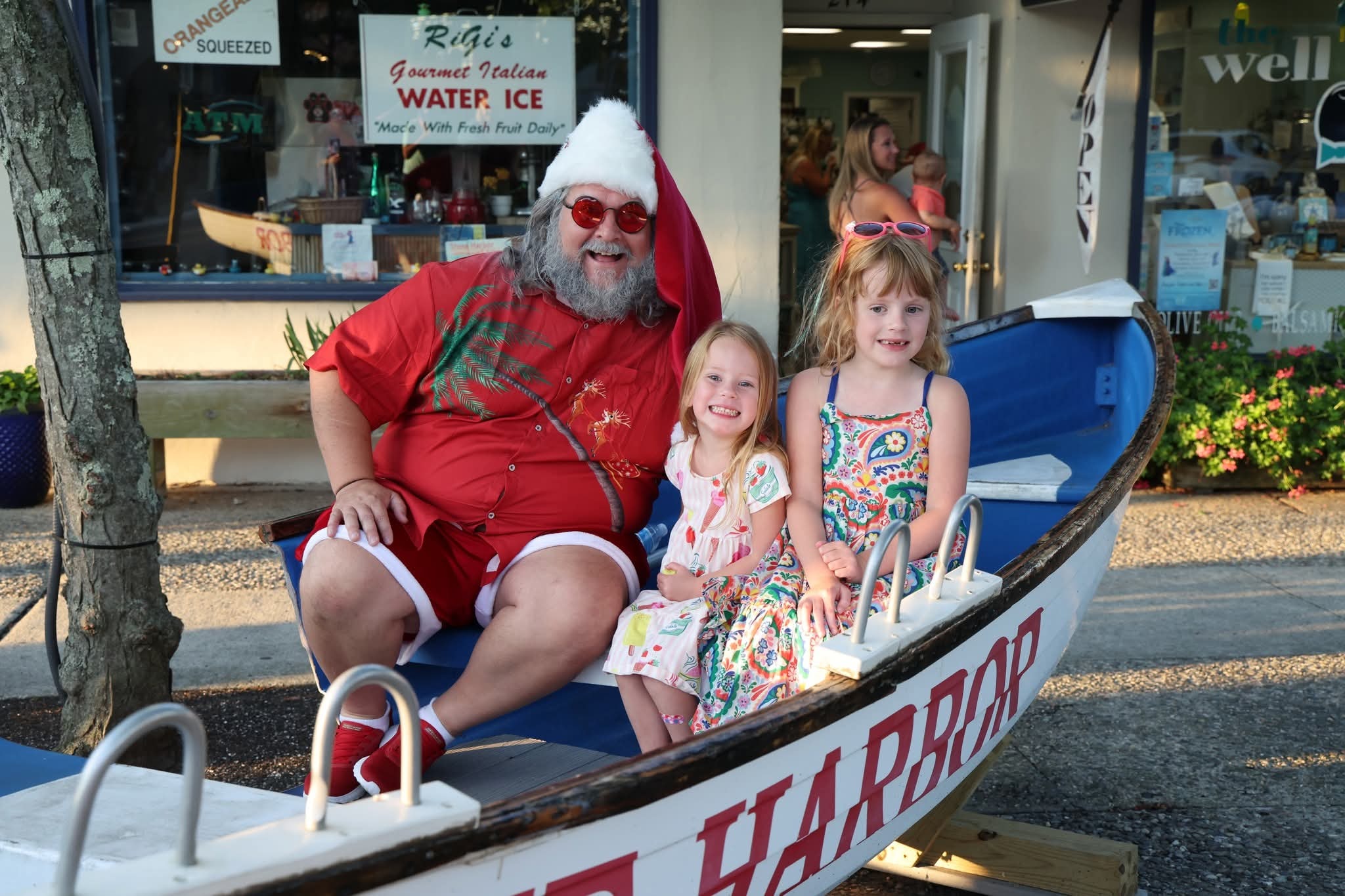 Cape May County Santa with two young girls in floral dresses in the Stone Harbor boat at golden hour