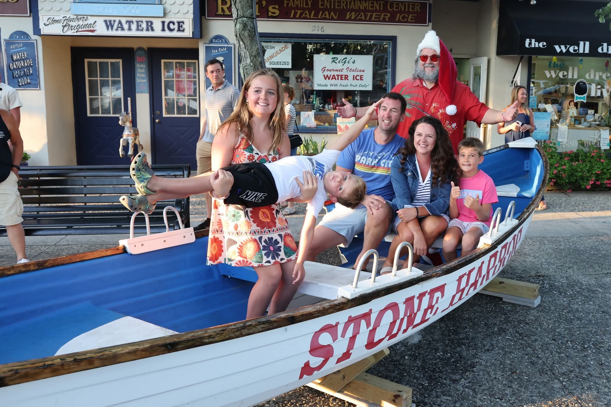 Cape May County Santa with a fun family of five including a girl holding a boy sideways in the Stone Harbor boat
