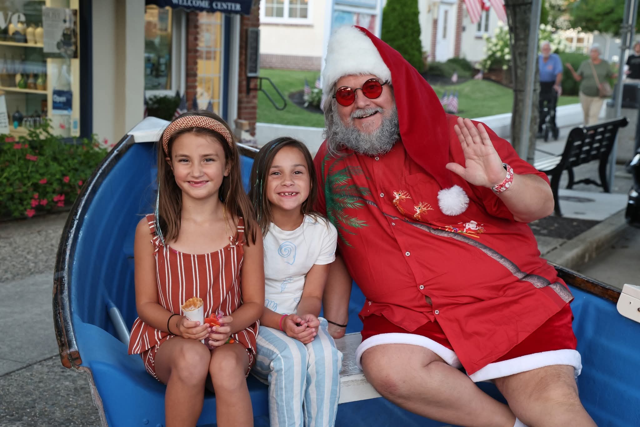 Cape May County Santa waving with two girls in the Stone Harbor boat near the Welcome Center